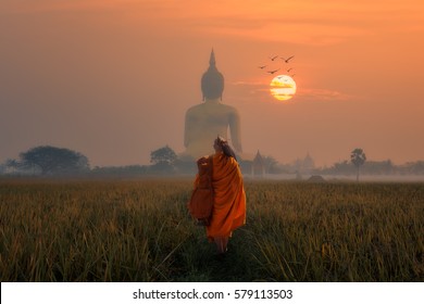 Asia Monk walking dhutanga behind Big Buddha at Wat Muang Angthong, Temple thailand in sunset.