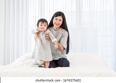 Asia mother hugs and play  baby  at white  room in the morning