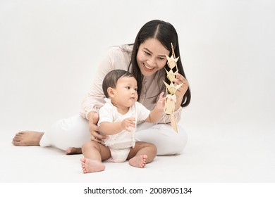 Asia Mother Plays With Her Baby Girl With Weave Fish On White Background. Concept Of Raising Children And The Importance Of Family.