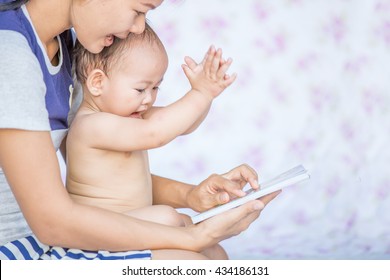 Asia Mother Reading Book For Her Baby