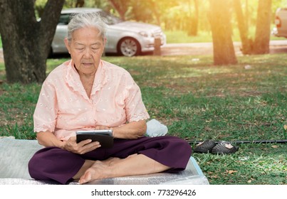 Asia Old Lady Using Tablet Outdoor At Park, Old Woman Playing Ipad On Park