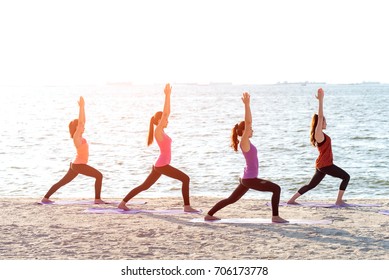 Asia people group making warrior pose on beach, fitness, sport, yoga and healthy lifestyle.  Healthy Concept