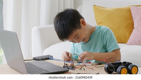 Asia People Home School Young Small Kid Happy Smile Laugh Self Study Online Lesson Excited Make AI Circuit Toy. STEM STEAM Digital Class On Laptop For Active Children Play Arduino Enjoy Fun Hobby.