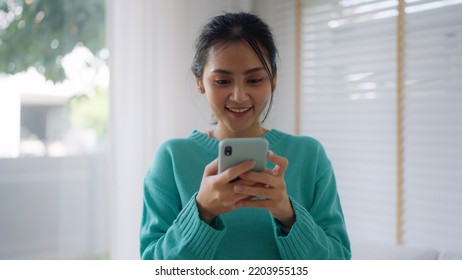 Asia People Single Woman Sit On Desk At Home Read And Look At Man Boy Photo Post On Phone. Relax Smile Choose Lover Enjoy Play Right Swipe On Tinder App To Find Love Couple In Fun Match Flirt Chat.