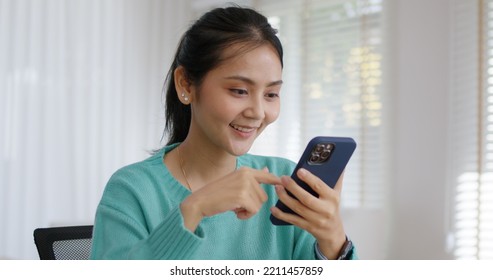 Asia people single woman sit on desk at home read and look at man boy photo post on phone. Relax smile choose lover enjoy play right swipe on tinder app to find love couple in fun match flirt chat. - Powered by Shutterstock