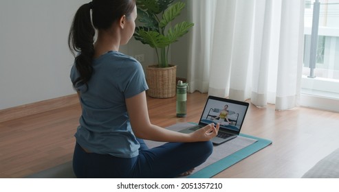 Asia People Sport Woman Enjoy Study Happy Watch Live Video Sit On Yoga Mat At Cozy Home Floor Indoor Easy Zen Class. Body Calm Life Stress Relax Asana Lotus Pose In Laptop Self Learn Online Media.