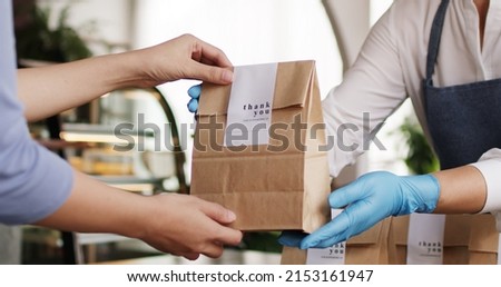 Asia people woman hand glove or face mask happy enjoy buy fast food carry send paper box pick up take home to-go lunch meal. Small cafe coffee shop work with wrap care new normal for SME omni channel.