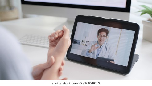 Asia people young woman worker work at home job video call telemedicine online clinic app for workforce care meet chat or tele consult to doctor remote advice teach to relax stiff neck or wrist pain. - Powered by Shutterstock