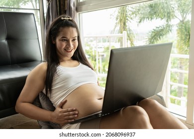 Asia Pregnant Mother Use A Computer For Online Shopping. She Smile And  Very Happy To See The Baby.The Idea Of Buying Baby Supplies.
