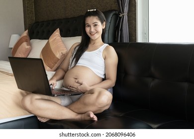 Asia Pregnant Mother Using A Computer For Online Shopping.The Idea Of Buying Baby Supplies