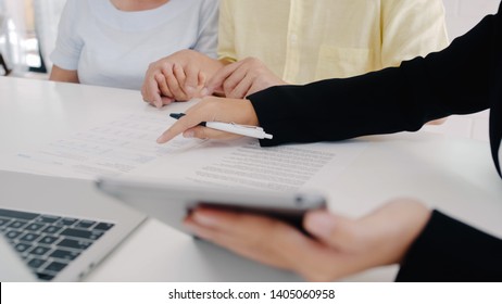 Asia Smart Female Agent Offers Health Insurance For Elderly Couples By Document, Tablet And Laptop. Aged Asian Couple Consulting With Insurance Agent While Sitting Together With At Home.