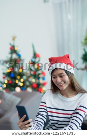 asia smile woman take selfie photo with mobile phone with blur christmas tree at xmas party,Live streaming video on social media event,Christmas holiday celebration party