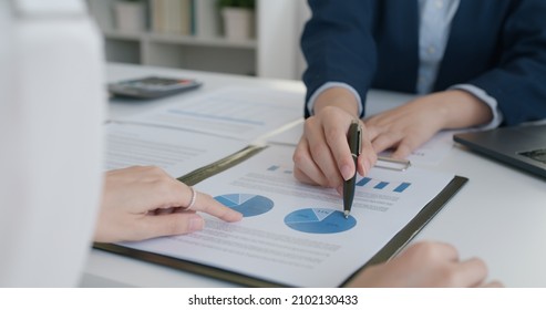 Asia stock trader agent or Sale tax loan broker advice brief and point hand to graph report talk to client at office desk show budget chart data or legal result on claim form. Trust will in work plan. - Shutterstock ID 2102130433
