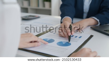Asia stock trader agent or Sale tax loan broker advice brief and point hand to graph report talk to client at office desk show budget chart data or legal result on claim form. Trust will in work plan.