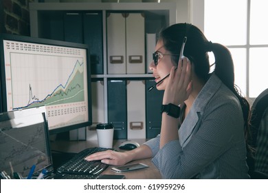 Asia Stock Trader Holding Microphone Talking With Client About Exchange Rate At Home. Woman Using Keyboard With Talking And Watching Computer.