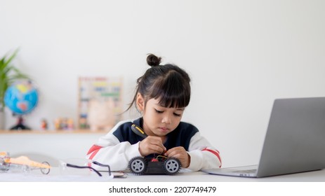 Asia students learn at home in coding robot cars and electronic board cables in STEM, STEAM, mathematics engineering science technology computer code in robotics for kids concept.