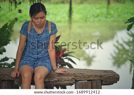 asia woman is sitt​ing​ at​garden​ very​ beautiful​