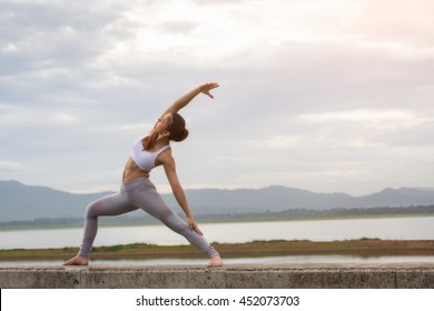 Asia Woman Doing Yoga Fitness Exercise For Relax And Healthy At Lake In Morning, Nature Background, Concept Outdoor Sport And Health