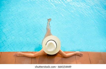 Asia estilo de vida de las mujeres relajándose cerca de la piscina de lujo baño de sol, día de verano en el complejo de playa en el hotel. Concepto de verano
