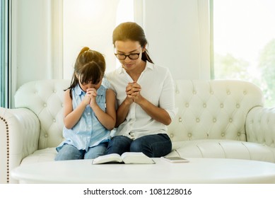 Asia woman and little girl  praying on holy bible on white background - Powered by Shutterstock