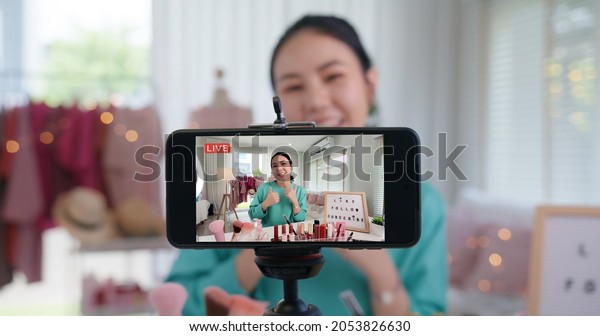 Asia woman micro influencer record live viral video\
camera at home studio. Happy youtuber fun talk speak advice review\
hobby in media. Vlogger selfie shoot enjoy work show smile teach\
like share app.