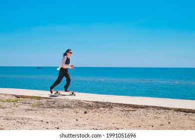 Asia woman playing longboard near the beach on vacation