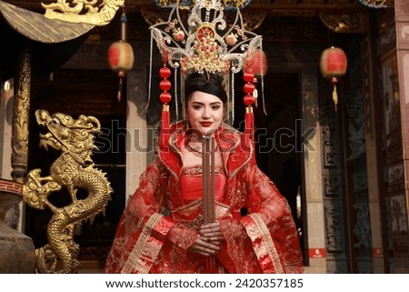  Asia woman with  Red traditional cheongsam qipao dress hold incense pray respect to buddha or forefather, Chinese New Year