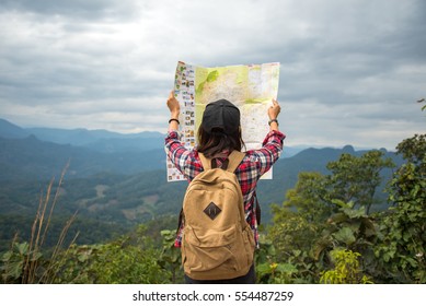 Asia Woman Traveler With Backpack Checks Map To Find Directions In Wilderness Area, Real Explorer.  Travel Concept