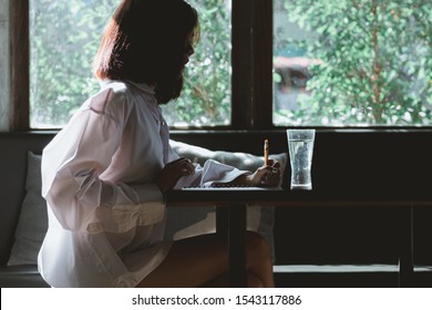 Asia  woman writing on the paper , thinking to somethig with loneliness.hearbroken woman concept