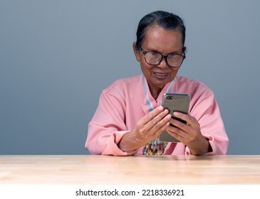 Asia Women Elderly Use Smartphone To Communication With Doctor And Check Health Care. Asia Woman Old, Senior, Person Is Smiling And Happily Holding Smartphone Online With Internet Using Social Media