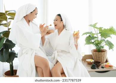 Asia women friends relaxing enjoy and spa massage with facial masks  tomato put on bathrobe.  Spa beauty massage healthy wellness.  Spa Thai therapy treatment aromatherapy for body woman - Powered by Shutterstock