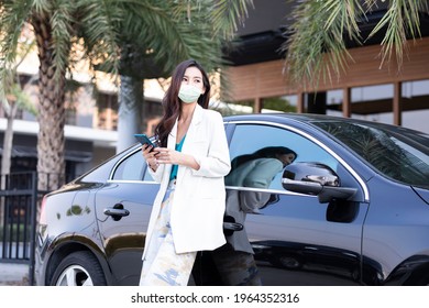 Asia Young Businesswoman Driving An Electric Car And Wearing Mask Preven Covid-19. 