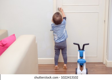 Asian 18 Months / 1 Year Old Toddler Baby Boy Standing On Tiptoes At Home, Kid Reaching Up Try To Open / Close Door Knob, Child Want To Escape To Play, Explore Outdoor, Security And Safety Concept