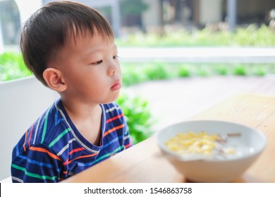 Asian 3 - 4  Years Old Toddler Boy Child Wearing Striped T Shirt Refuse To Eat Food, Little Unhappy Kid With No Appetite Bored Of Cereal As Breakfast,  Child Doesn't Want To Eat, Picky Eater Concept