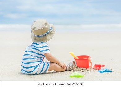 Asian 9 Months Baby Boy Playing On The Sandy Summer Beach Near The Sea. Summer, Travel, Holiday Concept