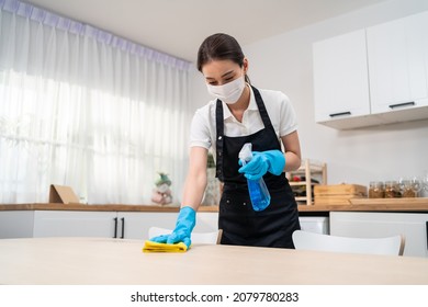 Asian Active Cleaning Service Woman Worker Cleaning In Kitchen At Home. Young Housekeeper Cleaner Wear Mask Feel Happy And Wiping Messy Dirty Dinner Table For Housekeeping Housework Or Chores In House