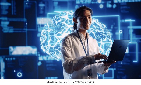 Asian admin in data center using artificial intelligence computing simulating human brain thought processes in computerized model. Employee holding laptop, working with AI machine learning algorithms