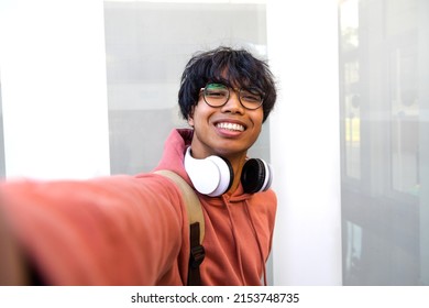 Asian Adolescent Male Taking Selfie With Phone Looking At Camera. Teen Boy College Students Take Photo Of Himself.