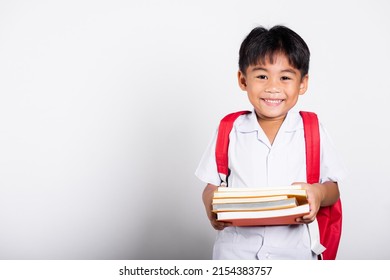 Asian adorable toddler smiling happy wearing student thai uniform red pants stand books for study ready for school isolated on white background, Portrait little children boy preschool, Back to school - Powered by Shutterstock