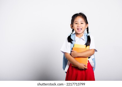 Asian Adorable Toddler Smiling Happy Wear Student Thai Uniform Red Skirt Stand Hold Or Hugging Book In Studio Shot Isolated On White Background, Portrait Little Children Girl Preschool, Back To School