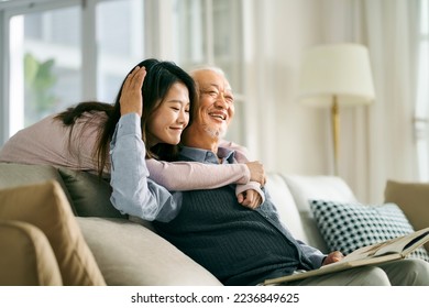 asian adult daughter and senior father enjoying conversation and good time at home - Shutterstock ID 2236849625