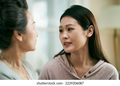 asian adult daughter talking to and comforting sad senior mother - Powered by Shutterstock