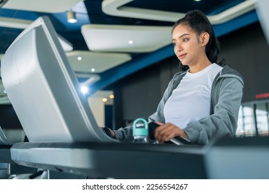 asian adult female sport woman jogger running on treadmill athletic working out active healthy lifestyle with cheerful freshness sweaty cardio exercise at fitness gym sport club morning wellness day - Shutterstock ID 2256554267