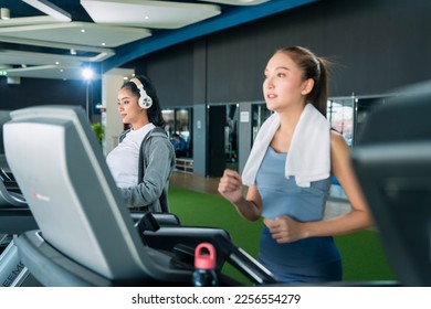 asian adult female sport woman jogger running on treadmill athletic working out active healthy lifestyle with cheerful freshness sweaty cardio exercise at fitness gym sport club morning wellness day - Shutterstock ID 2256554279
