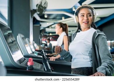 asian adult female sport woman jogger running on treadmill athletic working out active healthy lifestyle with cheerful freshness sweaty cardio exercise at fitness gym sport club morning wellness day - Shutterstock ID 2256554289