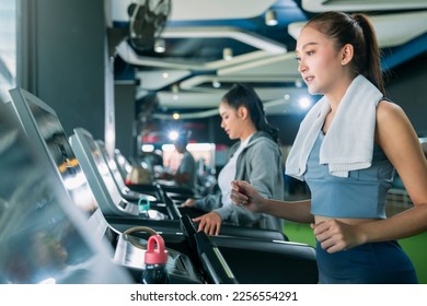asian adult female sport woman jogger running on treadmill athletic working out active healthy lifestyle with cheerful freshness sweaty cardio exercise at fitness gym sport club morning wellness day - Shutterstock ID 2256554291