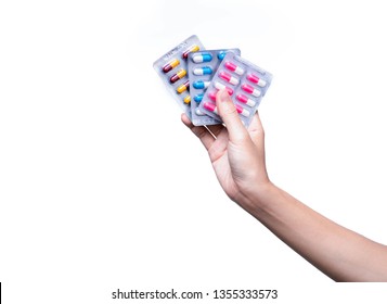 Asian adult hand holding antibiotics drug in blister pack. Woman hand hold three pack of capsule pills. Hand giving antibiotics drug isolated on white background. Antibiotic drug resistance concept. 