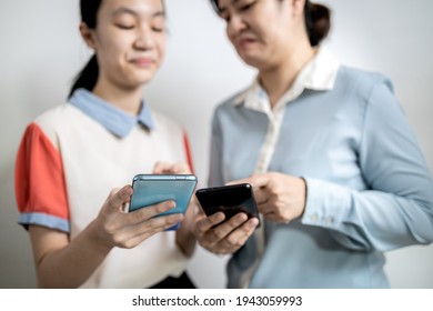 Asian Adult Woman Smirk Smile With Disdain On Her Face Shows Scornful Abuse,dissatisfied Teenage Lady Girl With Disrespect Expressing Contempt,envy Others,disgust As He Reads A Message On Mobile Phone