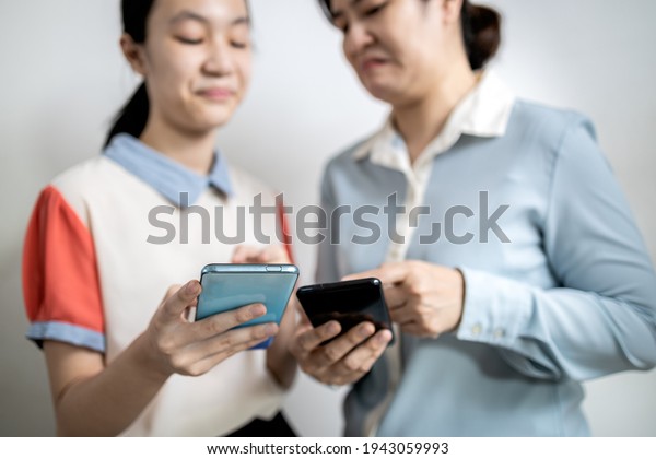 Asian adult woman smirk smile with disdain on her\
face shows scornful abuse,dissatisfied teenage lady girl with\
disrespect expressing contempt,envy others,disgust as he reads a\
message on mobile phone