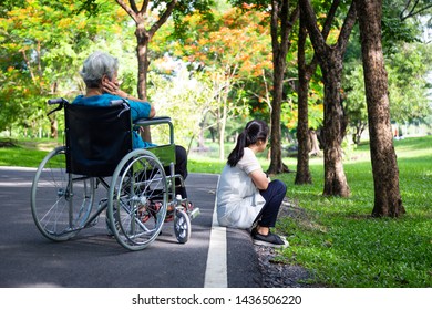 Asian Adult Woman Touchy And Angry Acting With Elderly People In Wheelchair After Senior Mother Argument With Daughter In Outdoor Park,relationship Difficulties,conflict,hurt,family Problems Concept